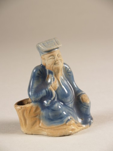 Waterdruppelaar in de vorm van een zittende man met blauwe mantel